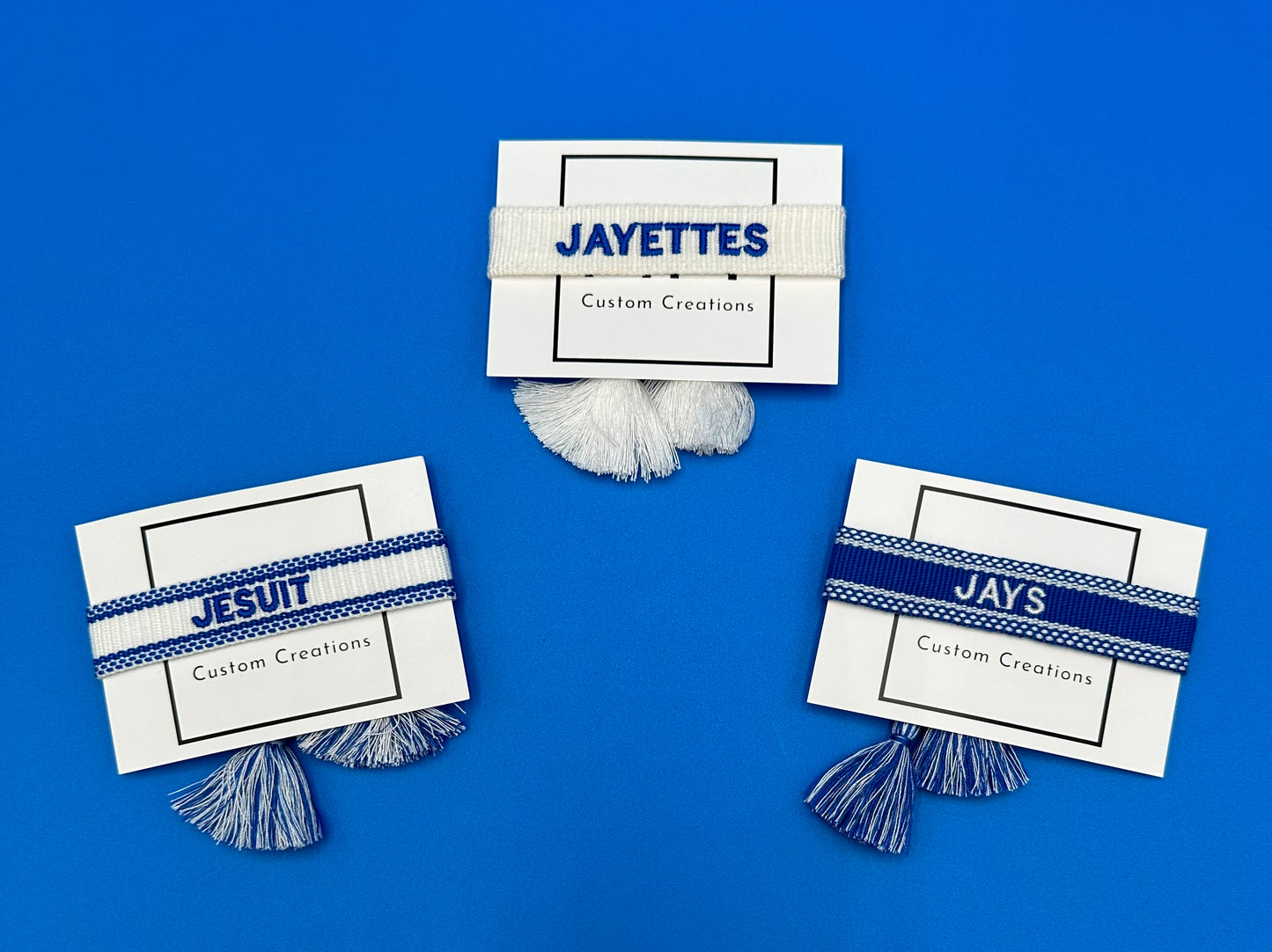 Custom Creations. Woven bracelets w/tassel - adjustable. Royal Blue & White. Available in three styles: JESUIT, JAYS & JAYETTES