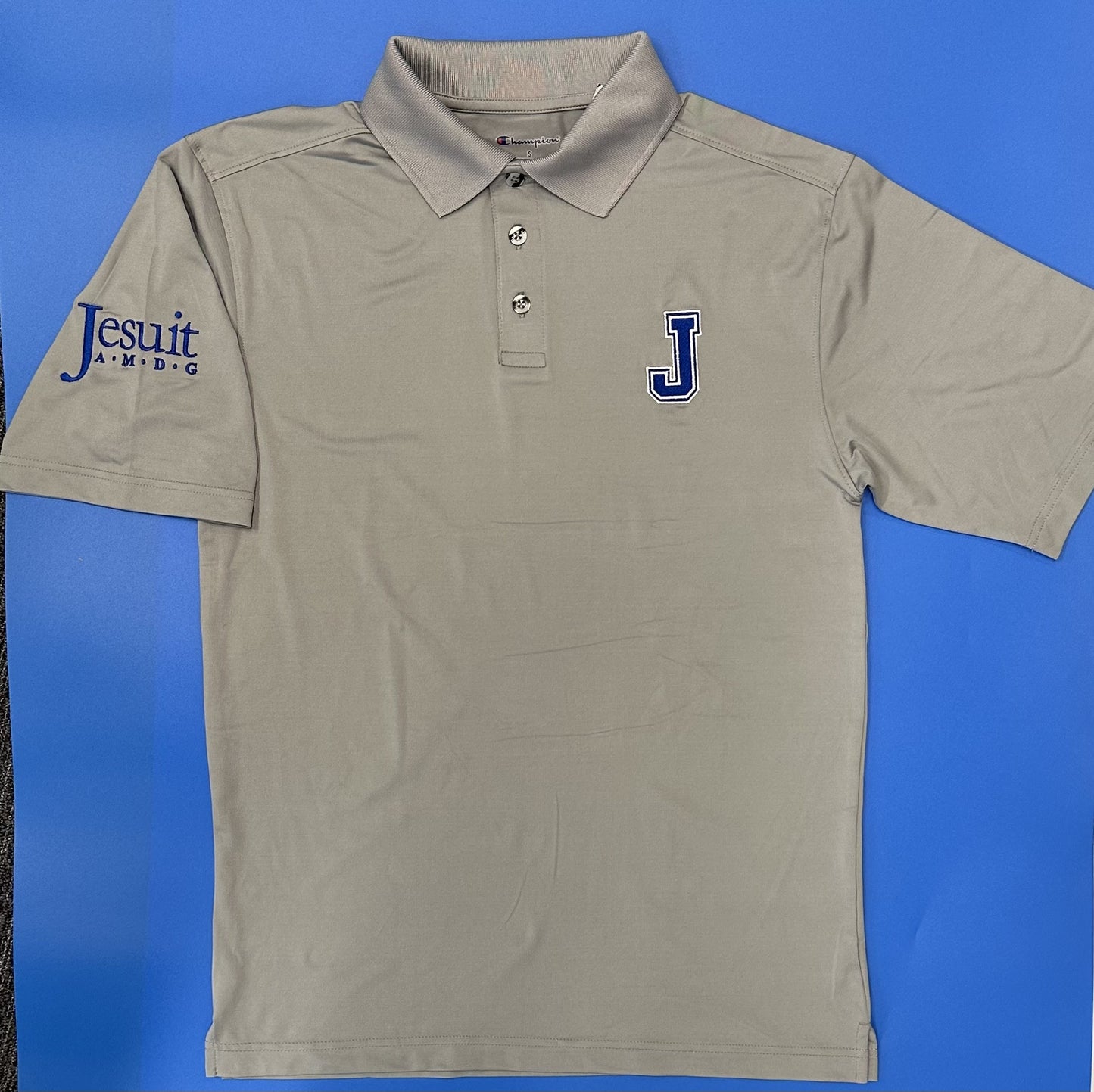 Champion. 90% Polyester/10% Elastane. From the 2024 Stadium Collection. Rib knit collar with 3-button placket. Standard finish sleeve and hem. Straight body fit with side vents for added movement. Embroidered J logo on left chest and Jesuit A. M. D. G. logo on right sleeve.