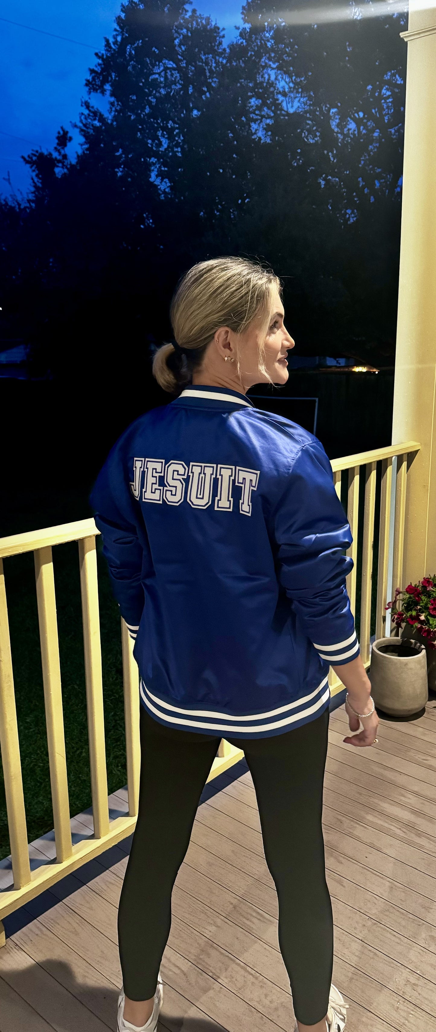 Champion.
100% Polyester Satin.
This Satin Bomber Jacket is a modern twist on the vintage varsity style. The jacket features a striped stand-up collar, cuffs and waistband. Jayson/J logo at left chest, and JESUIT displayed on the jacket's backside. Quilted lining. Wear it when you want to show off your Blue Jay spirit. Thank you for modeling Laura Tucker