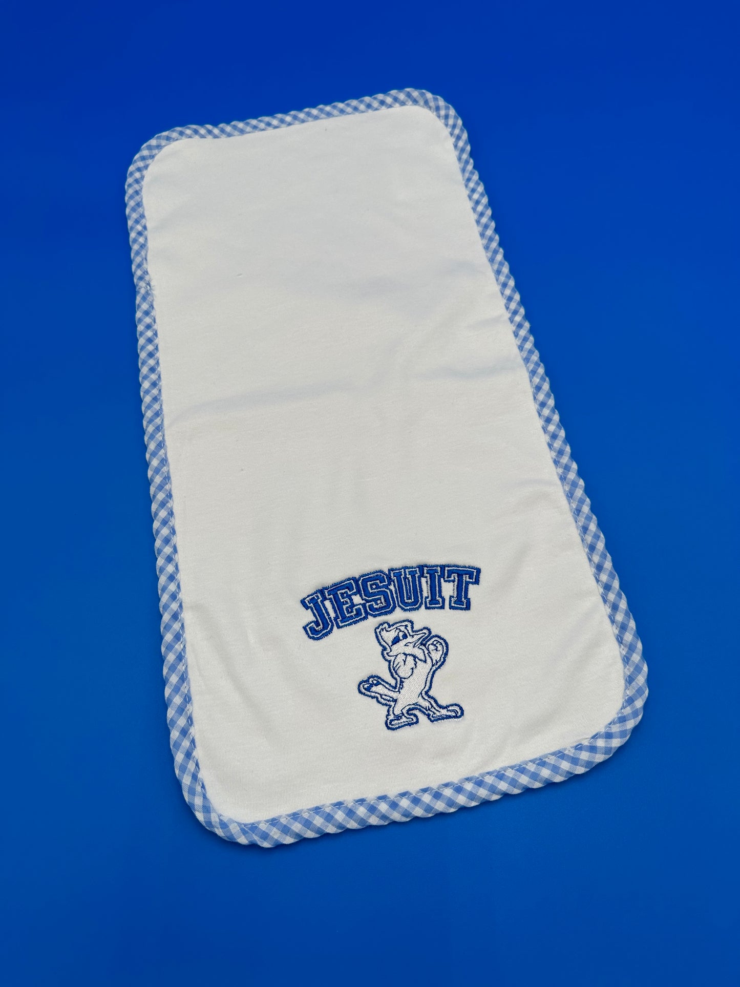 Blanks Boutique 100% combed cotton top layer w/chenille terry cloth back layer. Blue/White gingham check border. Embroidered Jesuit w/Jayson logo.