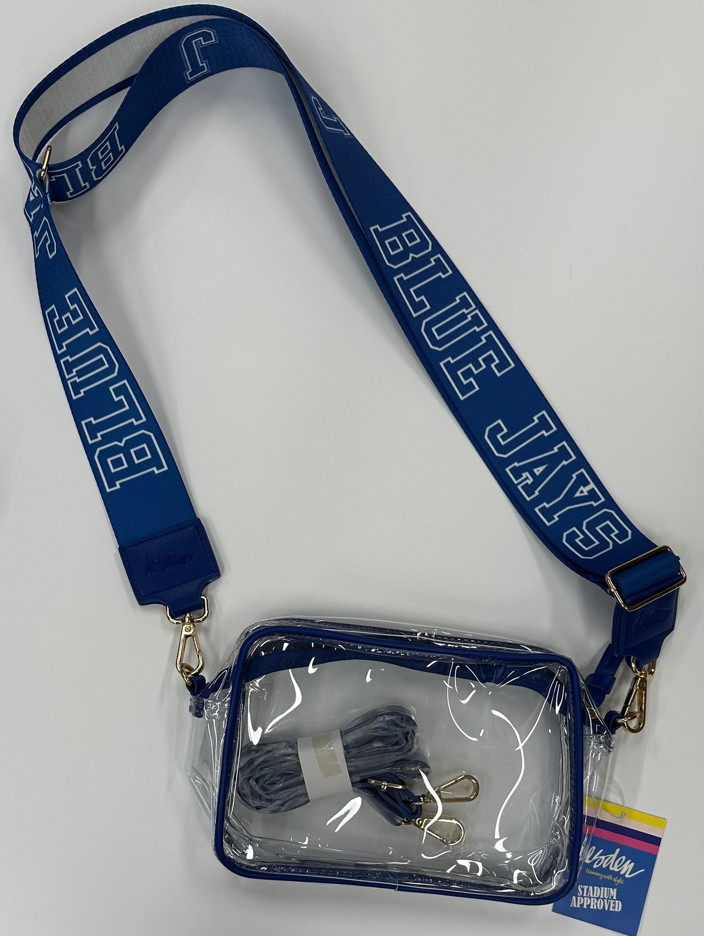 Stadium approved. Clear bags with vegan leather trim, zipper closure and removable straps. Comes with 2 sets of adjustable purse straps, one in matching vegan leather, a 2nd one is 2 inch wide BLUE JAYS & J on one side with Royal Blue/White stripe on opposite.
Bridget measures: 8"/6"/2" Rectangle shape.