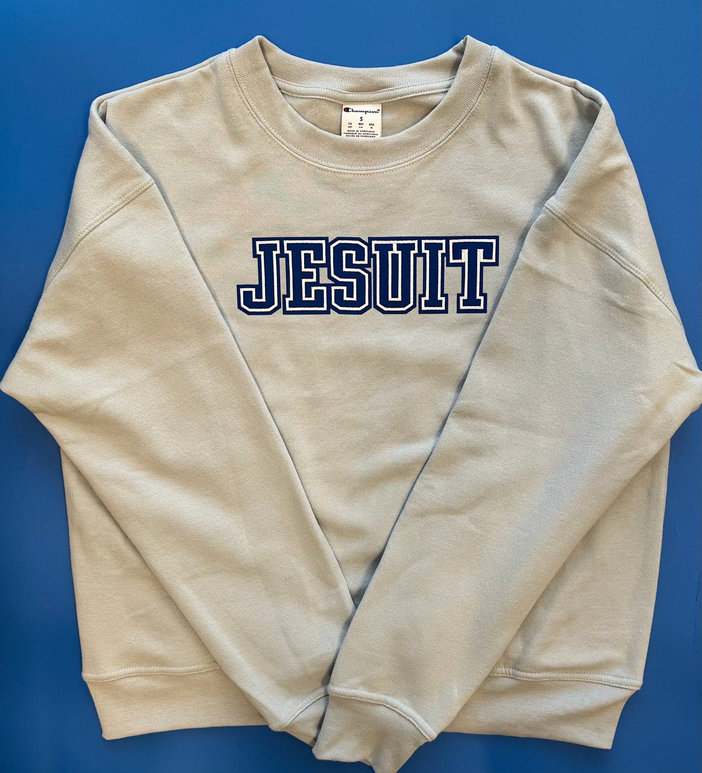 Champion.
50% Cotton/50% Polyester.
Rib collar, cuff, waistband.
Relaxed fit and modern length.
JESUIT logo.