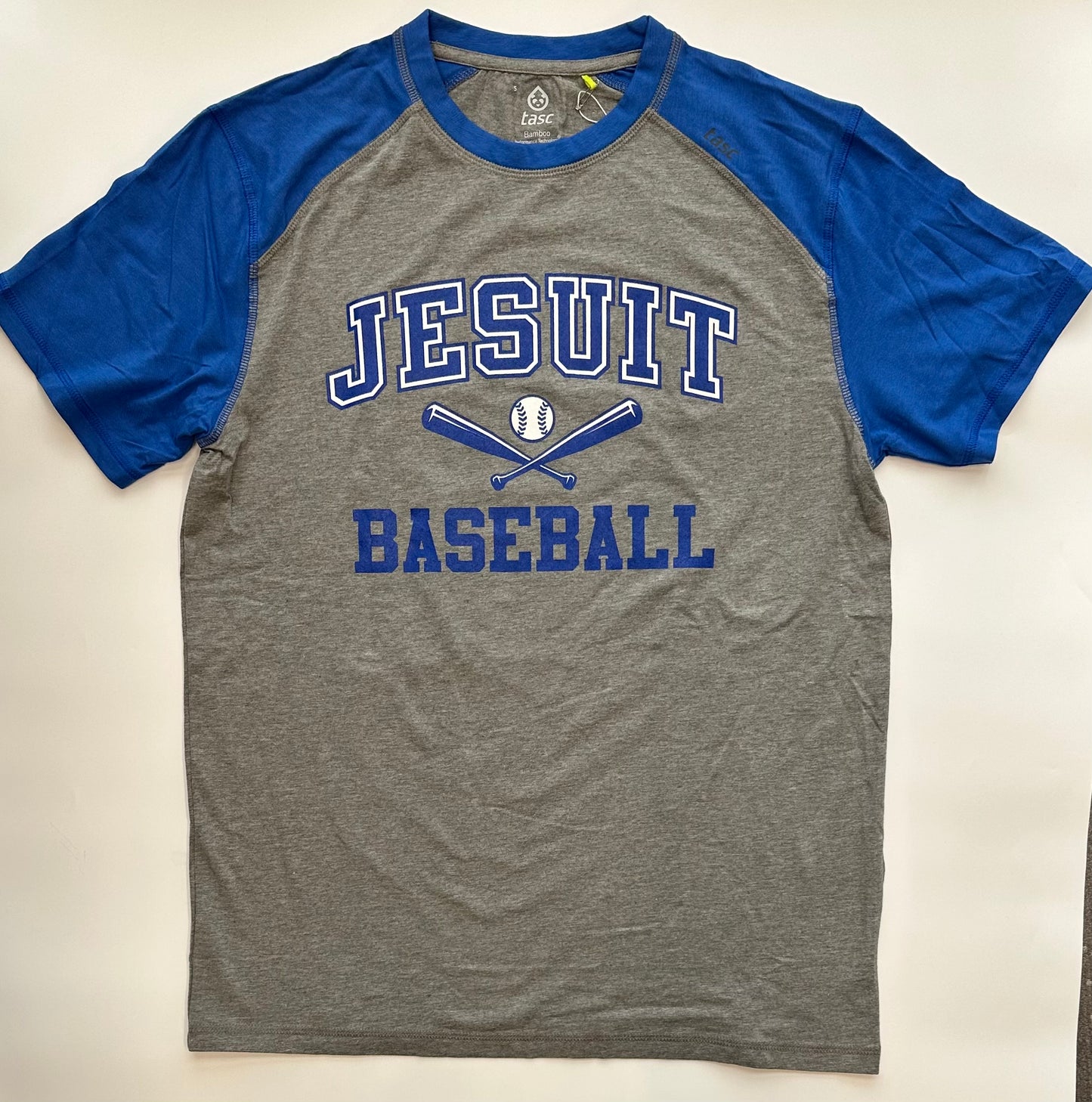 Tasc Performance.
Lightweight performance fabric for year-round comfort, modified raglan shoulder, 30" length. Body of shirt is Heather Grey and sleeves are Royal Blue
52% Organic Cotton/43% Viscose from Bamboo/5% Lycra Spandex.
Jesuit BASEBALL logo.