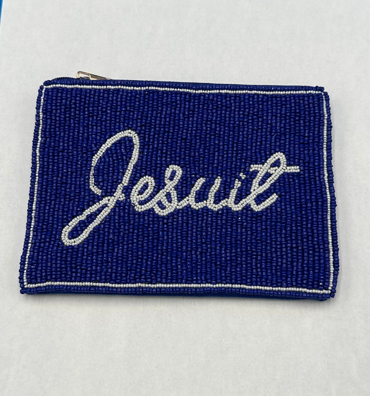 Desden.
A small pouch (measures 6 x 5 inches) that makes game day easier. This hand-beaded pouch has a secure zip-top closure, perfect for keeping essentials organized inside a clear purse. Designed to fit stadium-approved bags.
Jesuit script logo.