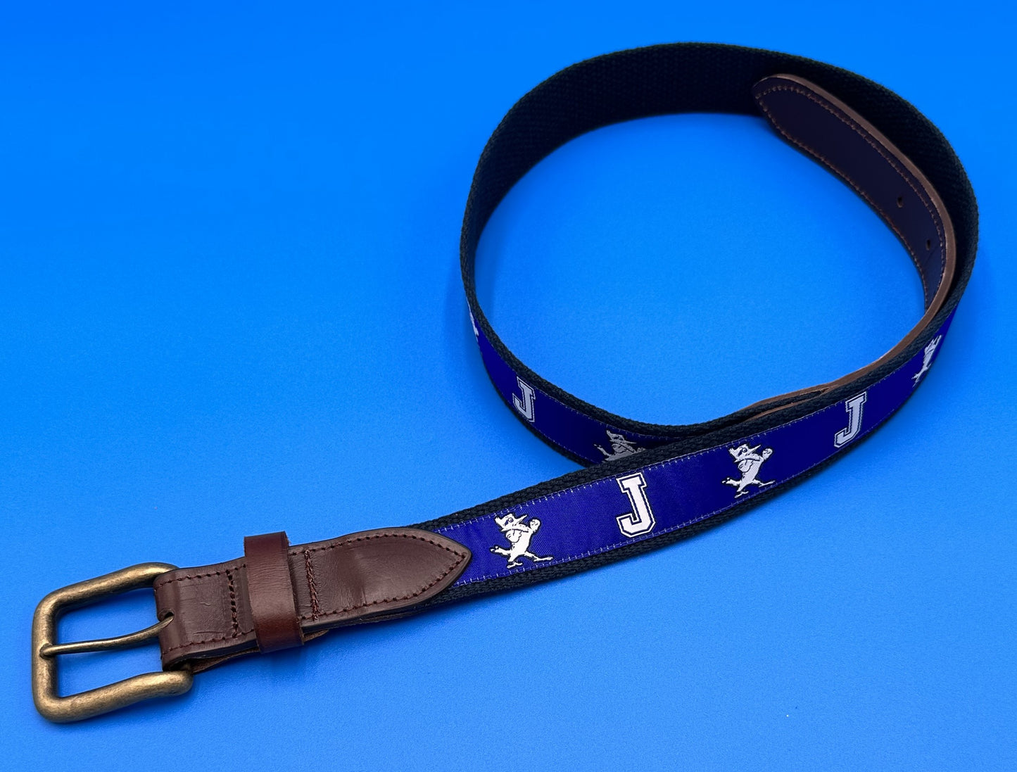 NOLA Couture. Woven Jesuit ribbon on a 100% cotton webbing base and finished with an antiqued brass buckle. Belt runs small so we suggest to size up ONE size.