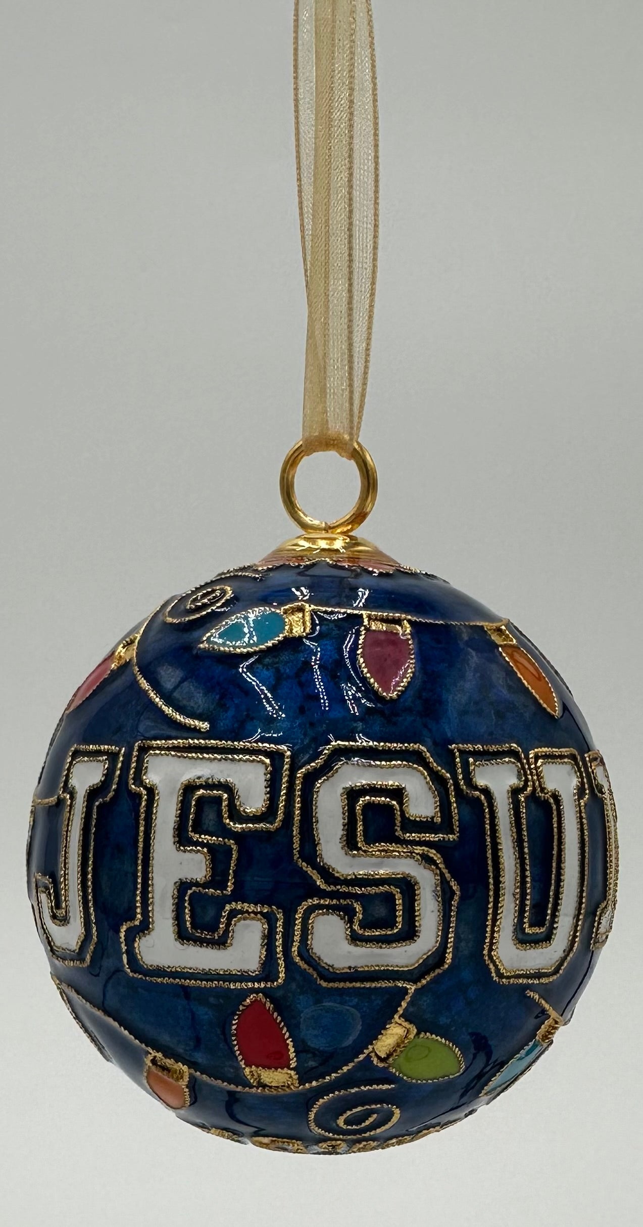 Kitty Keller Designs.
Our newest Christmas ornament to add to your collection. This year's round ornament features the JESUIT logo highlighted with festive Christmas lights and our beloved Jayson showing you exactly where we are located - NOLA!
Hand-crafted cloisonne ornaments are truly one-of-a-kind. Each gold-plated wire creating the design is formed and shaped by hand.
Comes in a silk covered gift box.