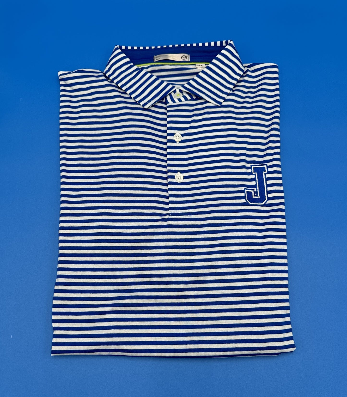 Tasc Performance. 48% Micro Modal/47% Micro Polyester/5% Elastane. Self-collar with permanent stays. 1 inch drop tail with side slits. 29.5-inch front/30.5-inch back length. Relaxed fit. J embroidered logo.