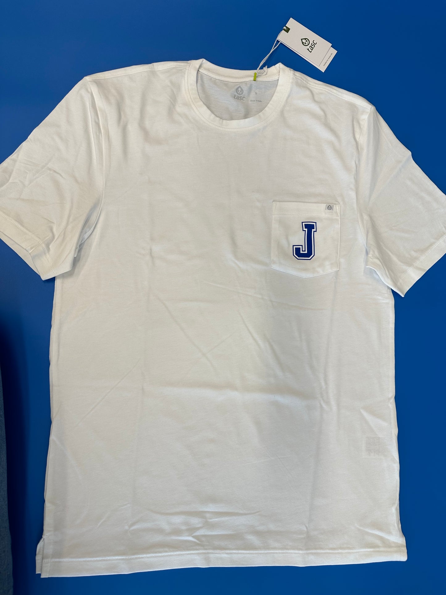 Tasc Performance. 52% Organic Cotton/43% Viscose from Bamboo/5% Lycra. Self-collar, reverse chain stitch at shoulders, railroad stitch at sleeve finish & hem. J logo on pocket.