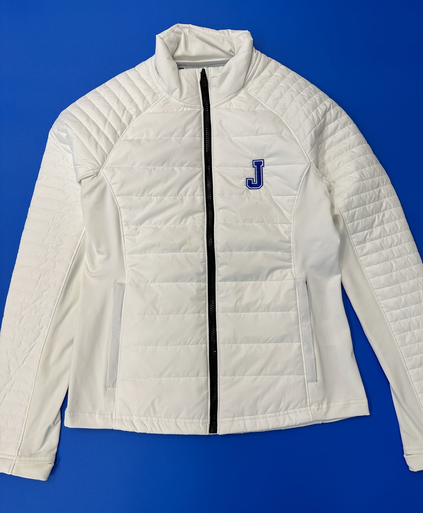 Under Armour 100% Nylon w/100% Polyester filling. Side Panels: 88% Polyester/12% Elastane. Princess lines w/in-seam pockets.