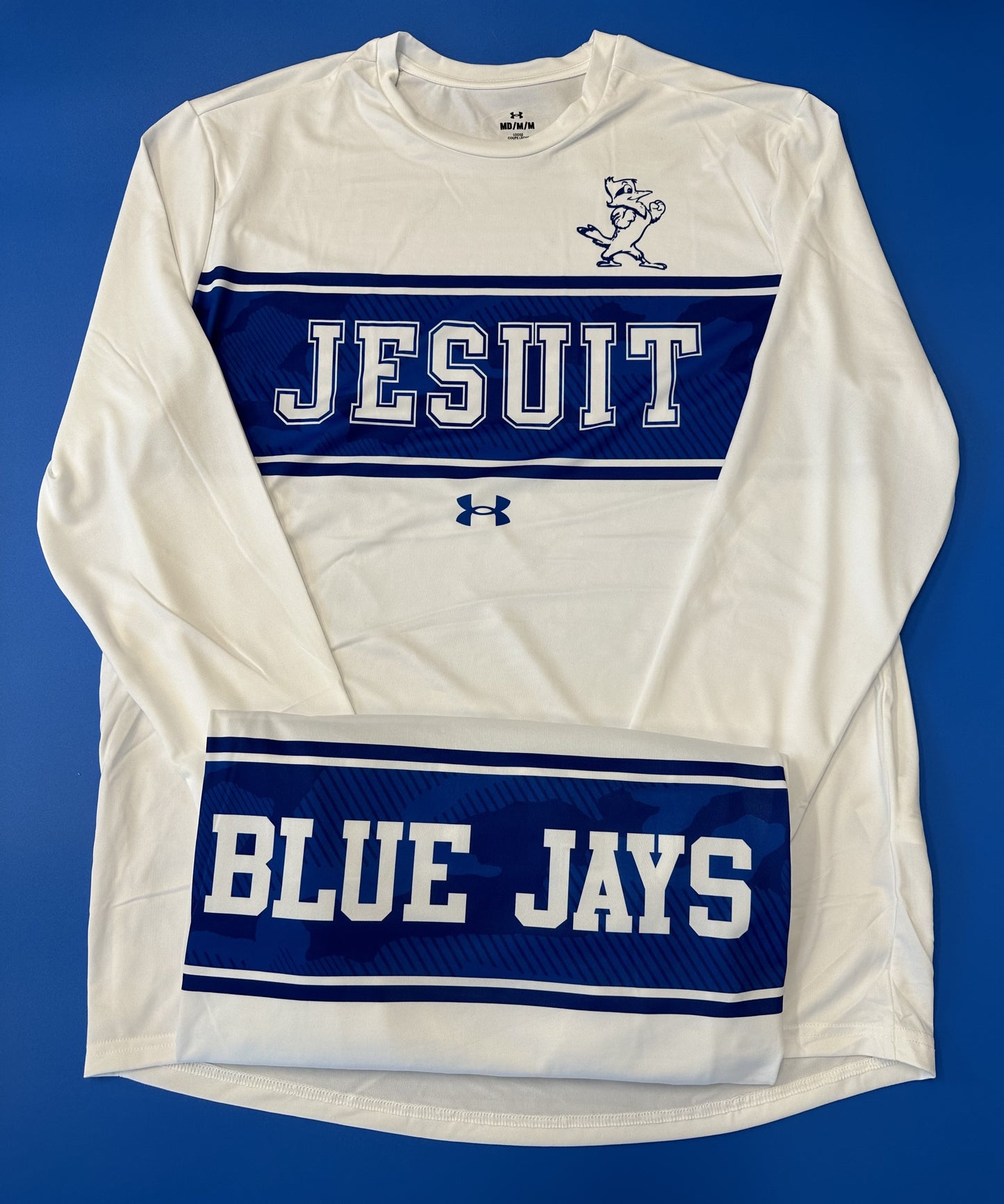 Under Armour Performance Fabric. JESUIT logo on front w/BLUE JAYS on backside. 100% Polyester.