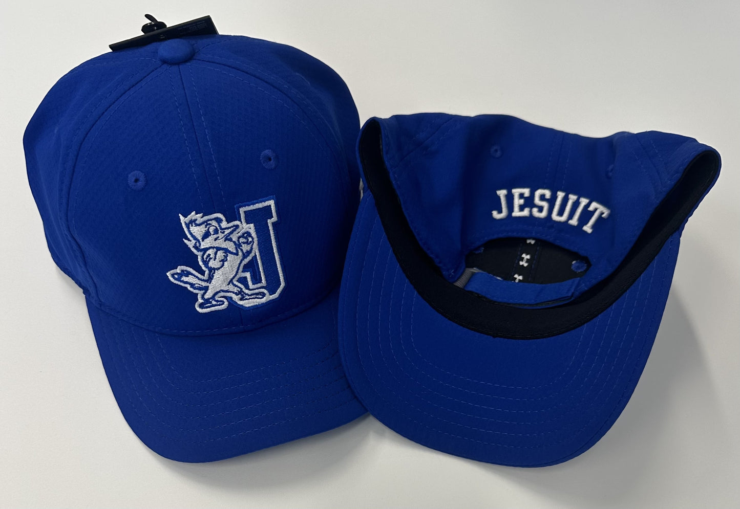 Under Armour 100% Polyester. Relaxed soft structure. Youth Size. J/Jayson on front/JESUIT on back.