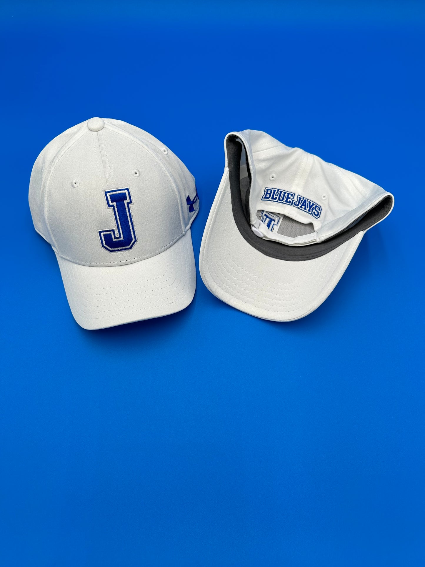 Under Armour 100% Polyester. Relaxed unstructured adjustable. Antimicrobial fabric. 6 panel construction w/elastic back Velcro closure. J with Blue Jays on backside.