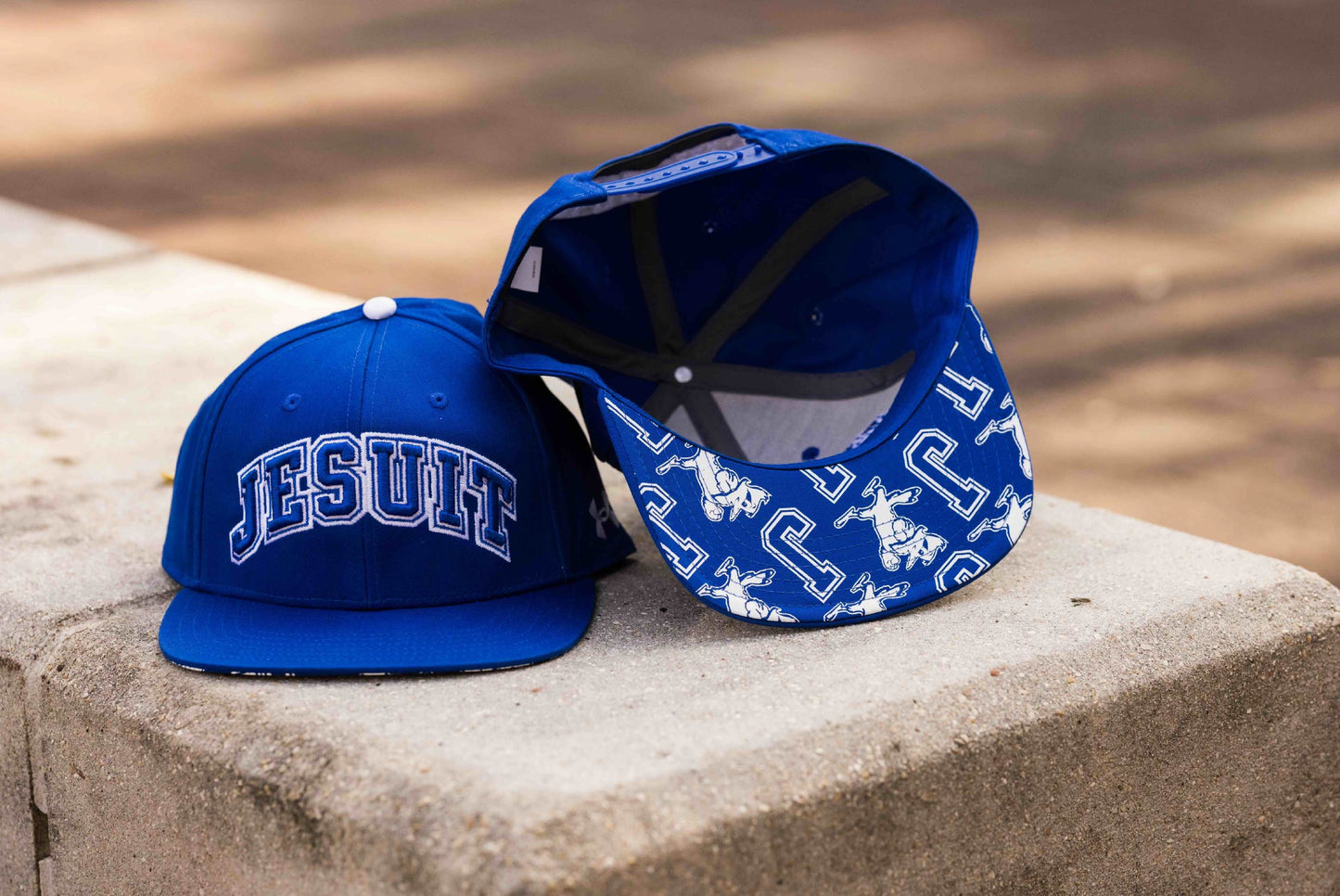 Under Armour.
One Size Fits Most.
100% Cotton Flat Bill Royal Blue hat with 3D JESUIT logo. Blue Jays on backside.
Underside of flat bill has Jayson and J logos.
Snapback closure.