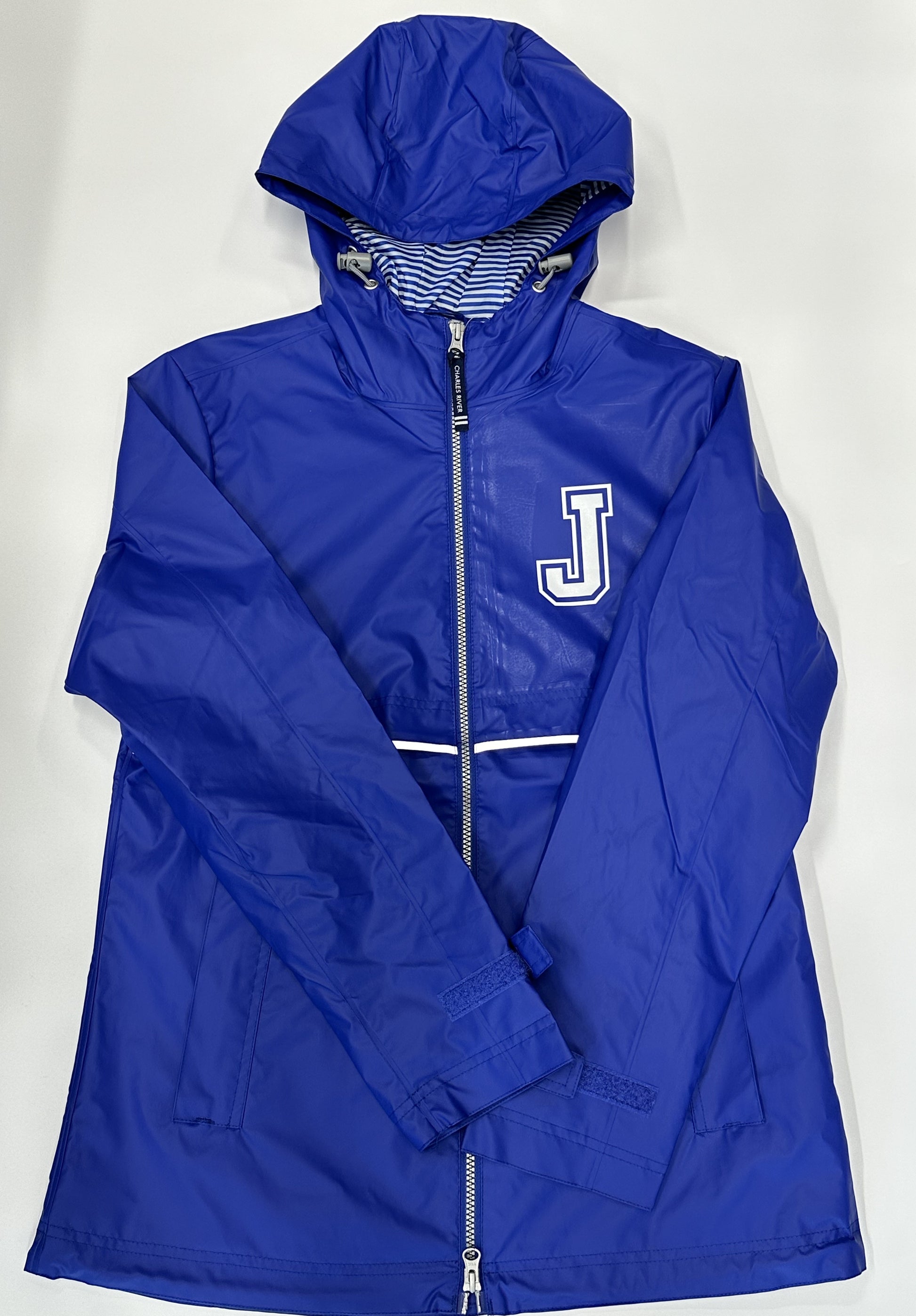 Charles River.  Shell:  100% Polyurethane/Backing:  100% Polyester.  Wind and waterproof w/heat sealed seams for weather protection.  Reflective trims across front & back for visibility.  Royal/White Stripe print lining - 100% polyester.