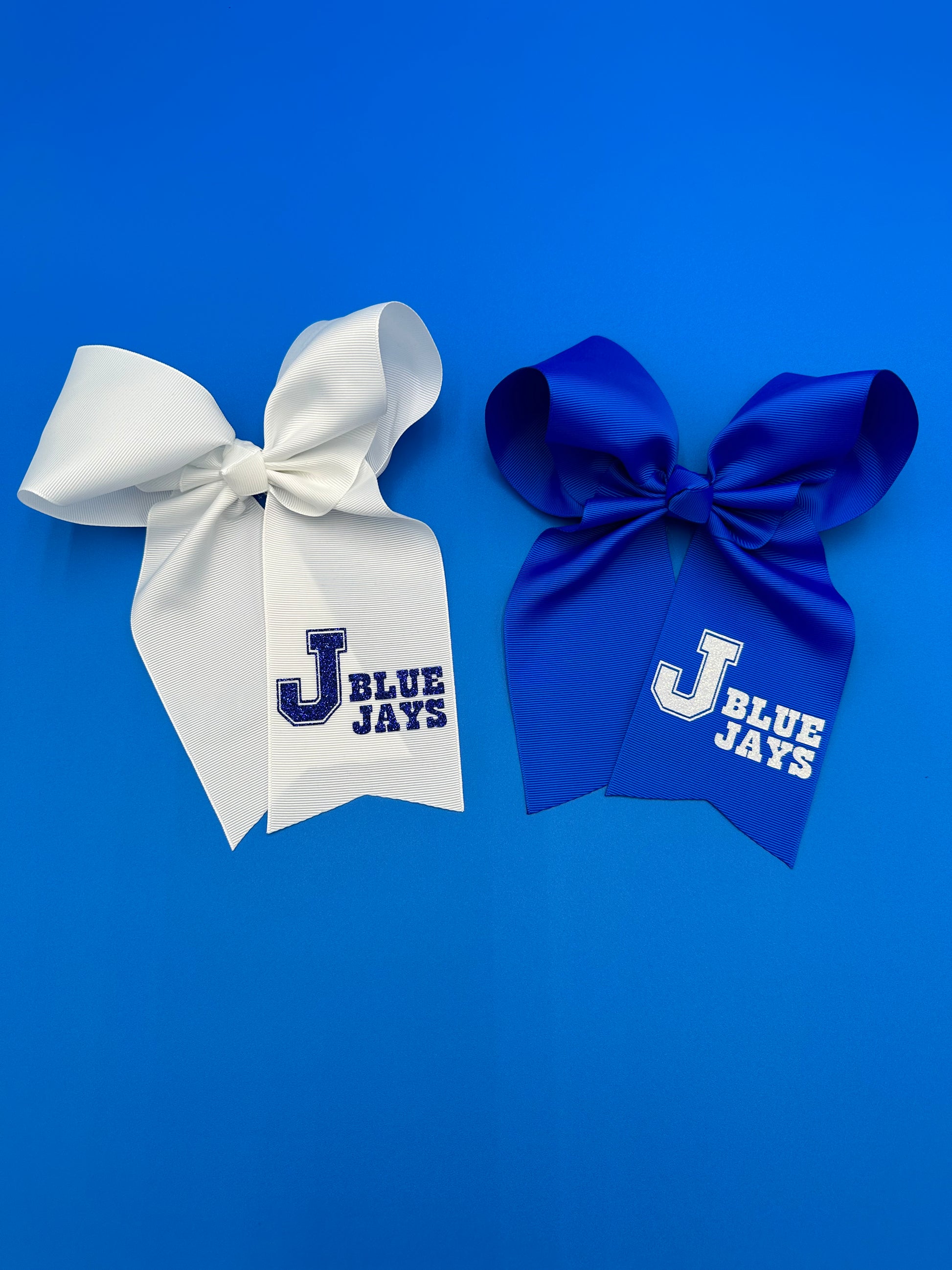 Cheer style large bows.  Made with 3 inch ribbon in two colors!  6 to 7" drop.  Alligator clip to hold in place.