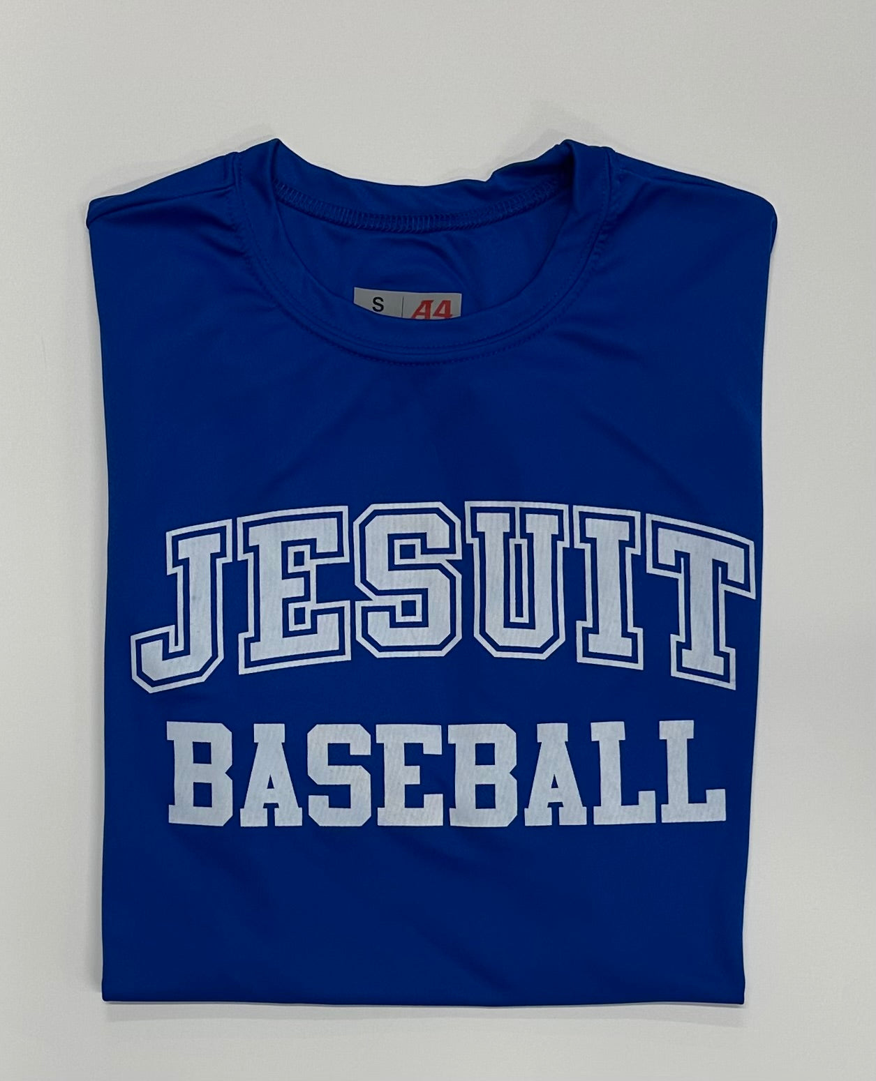 A4.

100% Polyester.

Features stain resistant, odor-resistant fabric for easy care. Moisture wicking for peak performance. UPF 44+ sun protection.&nbsp; Set in short sleeves.

JESUIT BASEBALL LOGO.