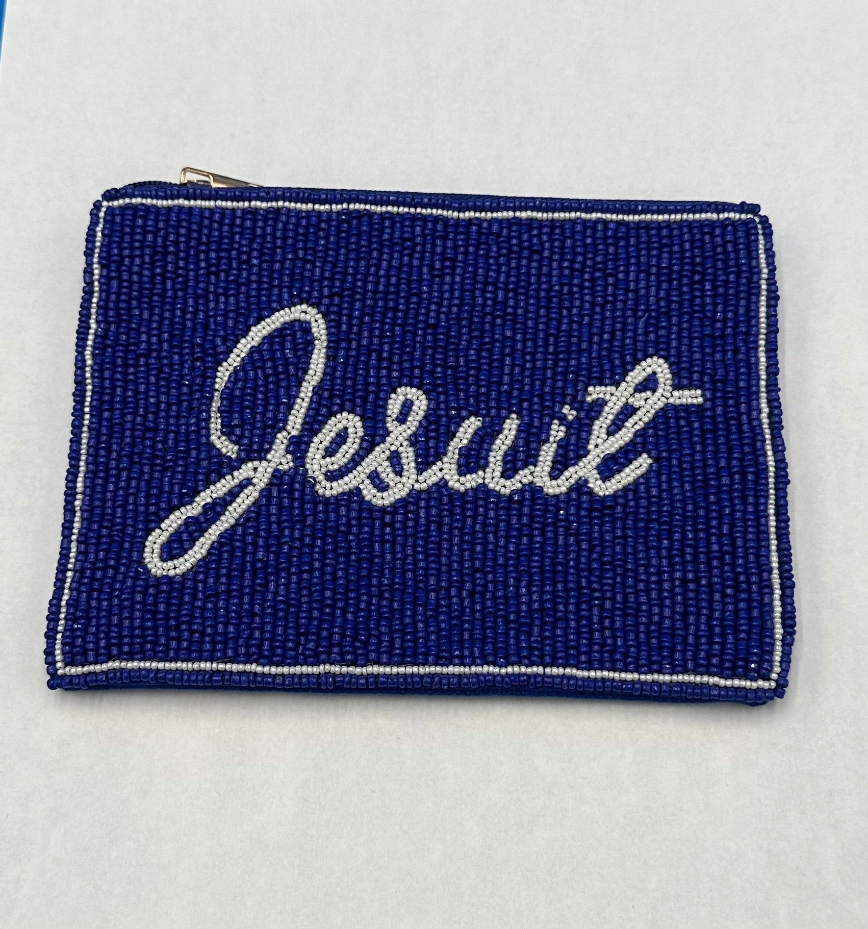 Desden.

A small pouch (measures 6 x 5 inches) that makes game day easier. This hand-beaded pouch has a secure zip-top closure, perfect for keeping essentials organized inside a clear purse. Designed to fit stadium-approved bags.

Jesuit script logo.