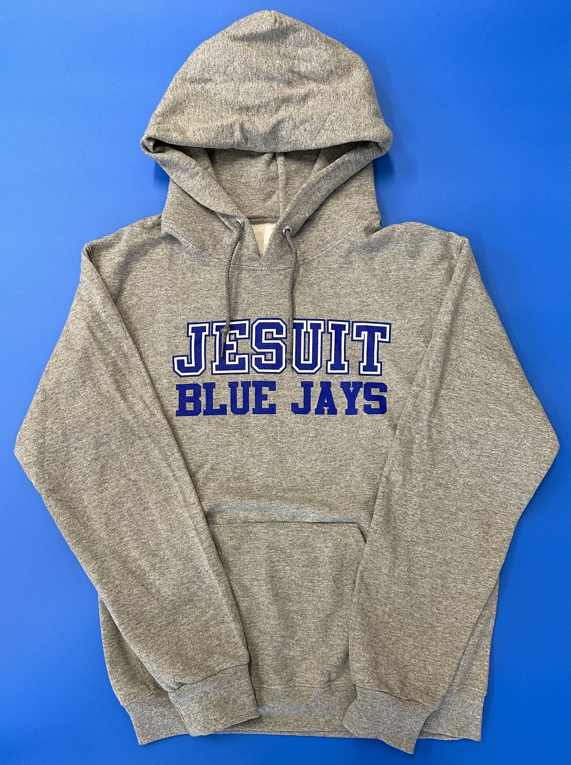 Jerzees.  51% Polyester/49% Cotton.  2 ply hood with grommets.  Front pouch pocket. 1 x 1 rib cuffs and waistband.  Screen printed Jesuit Blue Jays logo.
