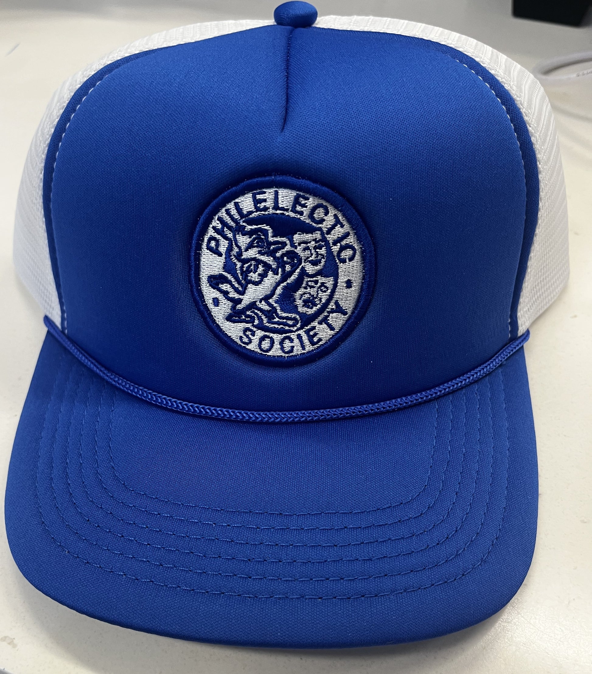 Pacific Headwear.

Trucker mesh side and back panels with foam front panel. Snapback detail. Has a slight curve in the visor and Royal Blue cording.

JESUIT PHILELECTIC SOCIETY LOGO.
