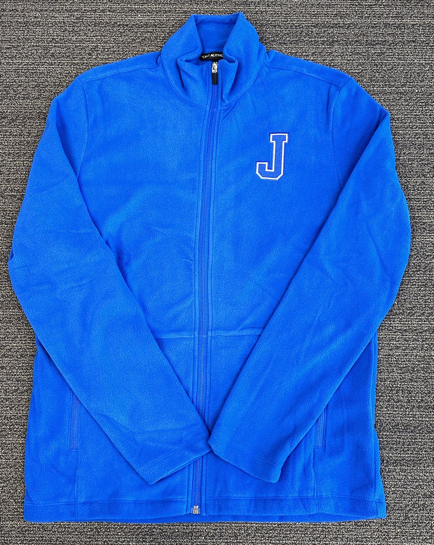 Port Authority.  100% Polyester/13.8 ounce.  Twill-taped neck. Full zip w/zippered pockets. Soft fleece jacket will keep you warm!  Embroidered J logo.