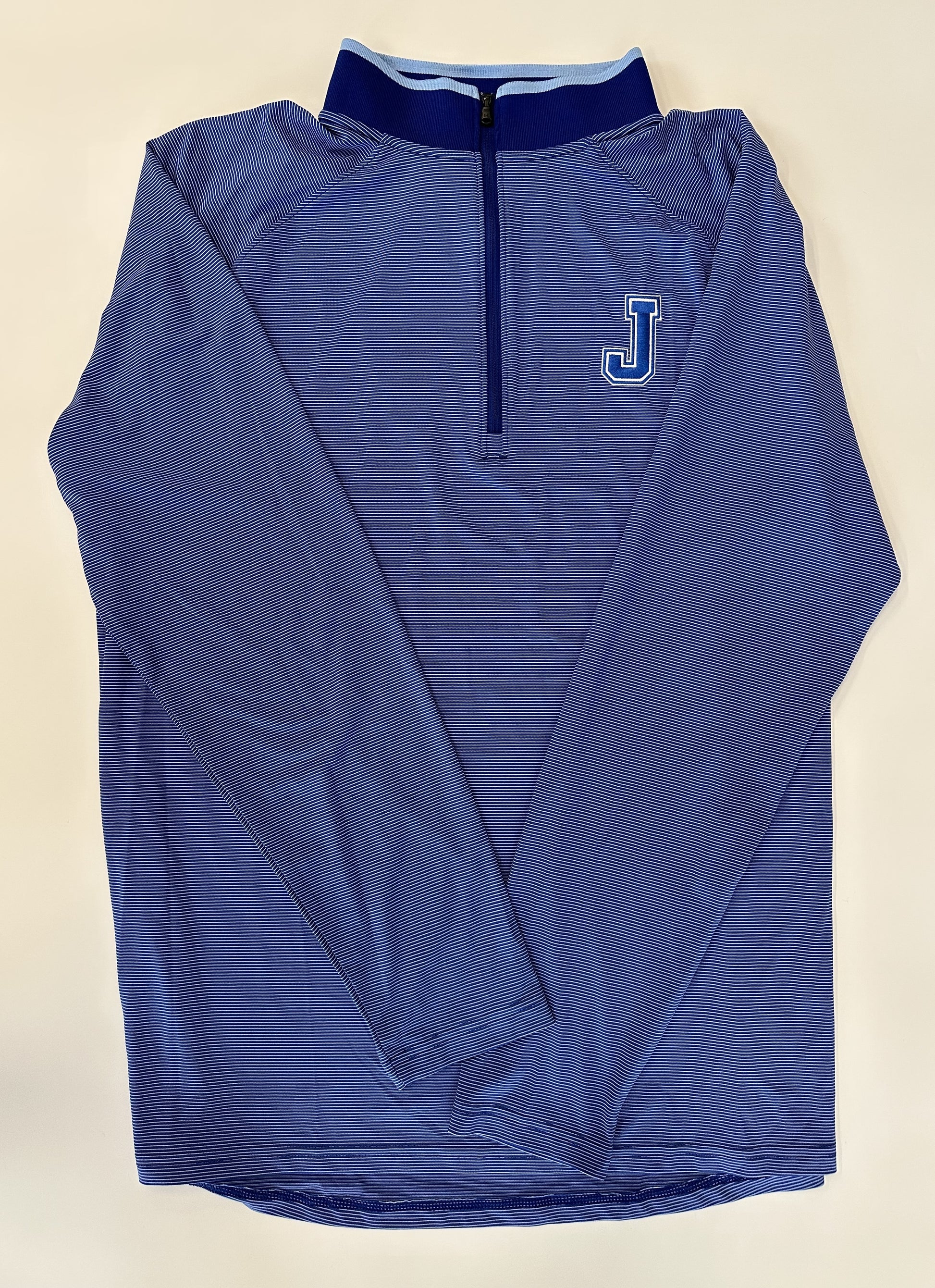 Under Armour.  88% Polyester/12% Elastane  Performance Fabric.  Embroidered J logo.